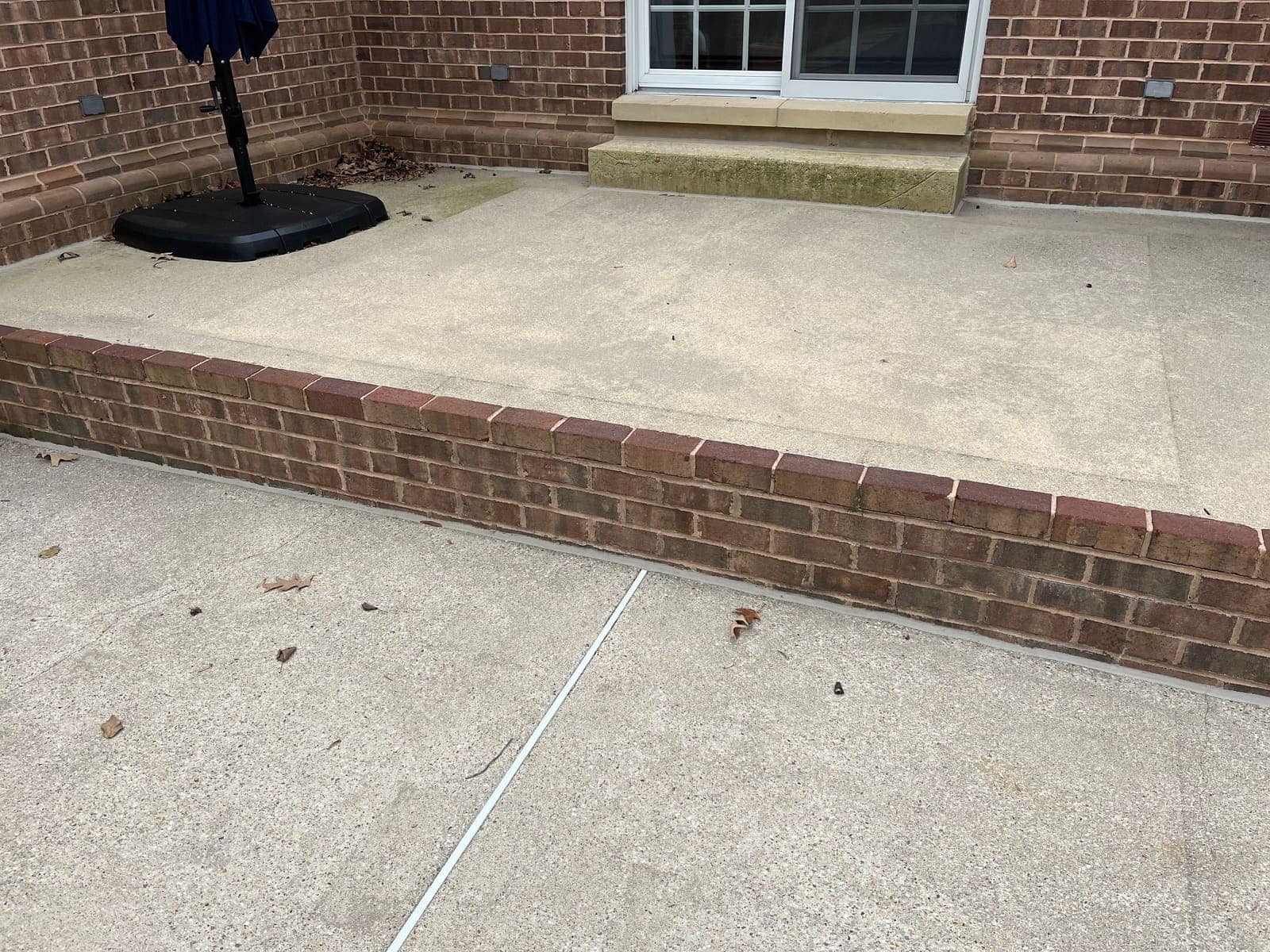 Brick-bordered concrete patio after cleaning