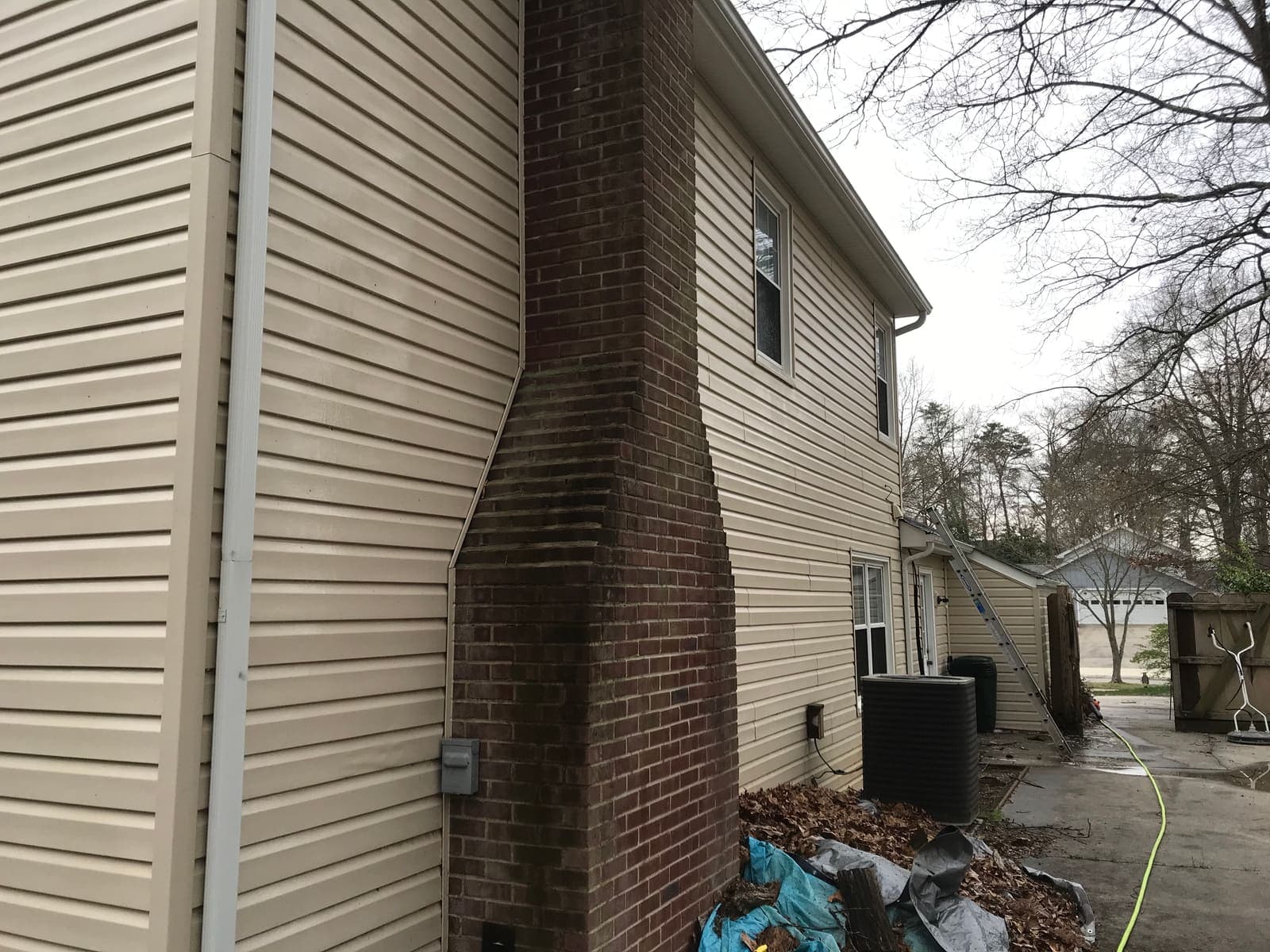 Rust and algae stains down a chimney and siding before cleaning