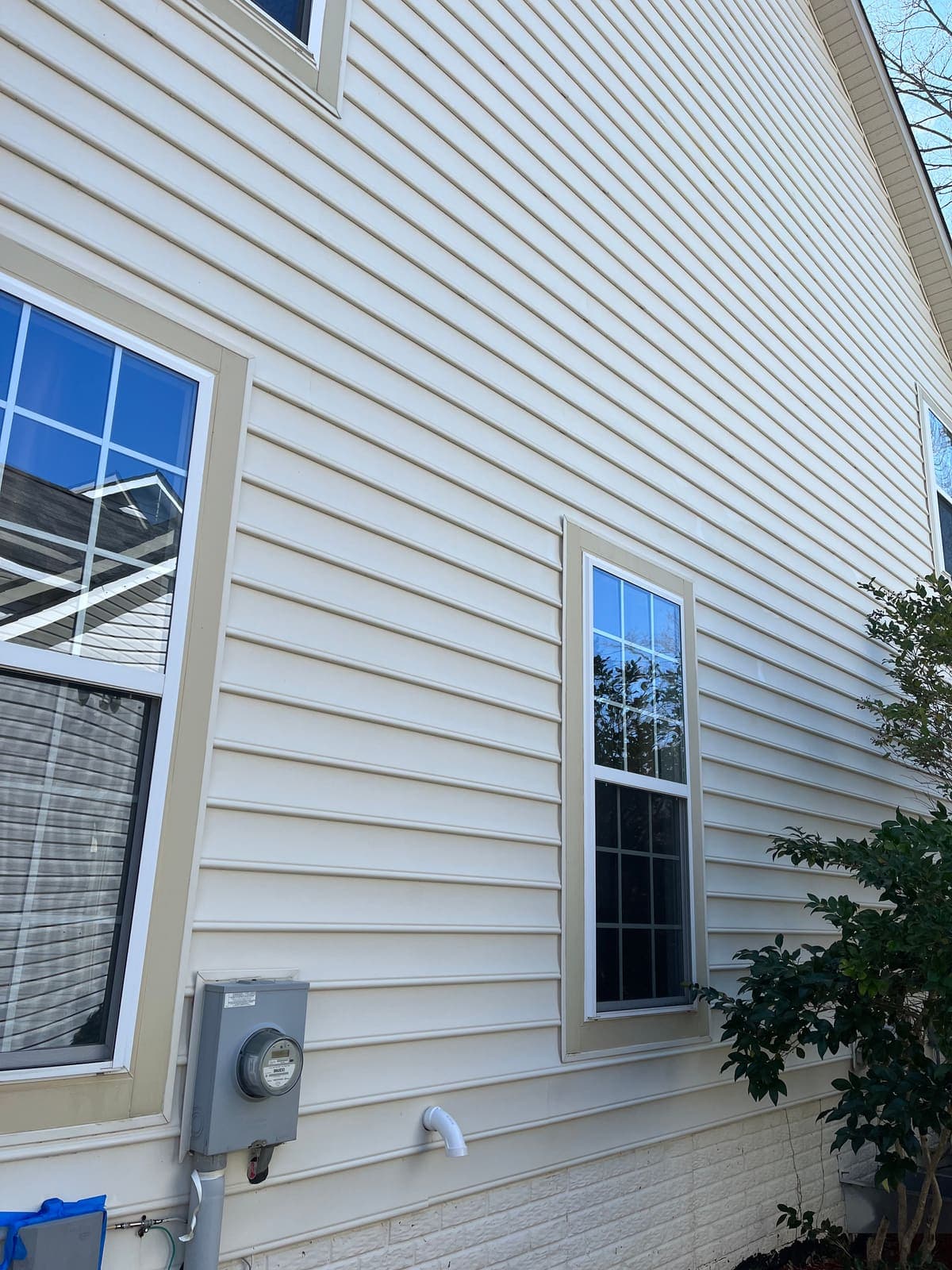 Clean siding and window trim after house washing