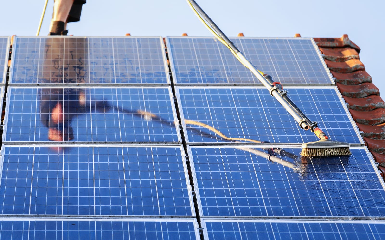 Cleaning rooftop solar panels with a soft brush