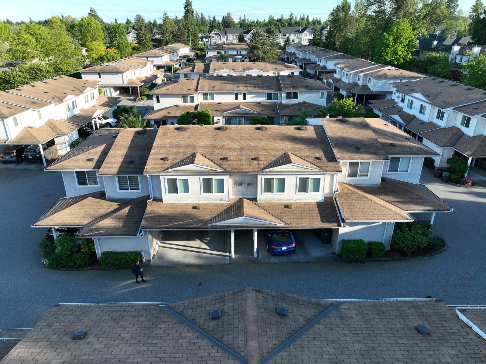 Drone view of a townhouse roof heavily darkened by moss before cleaning