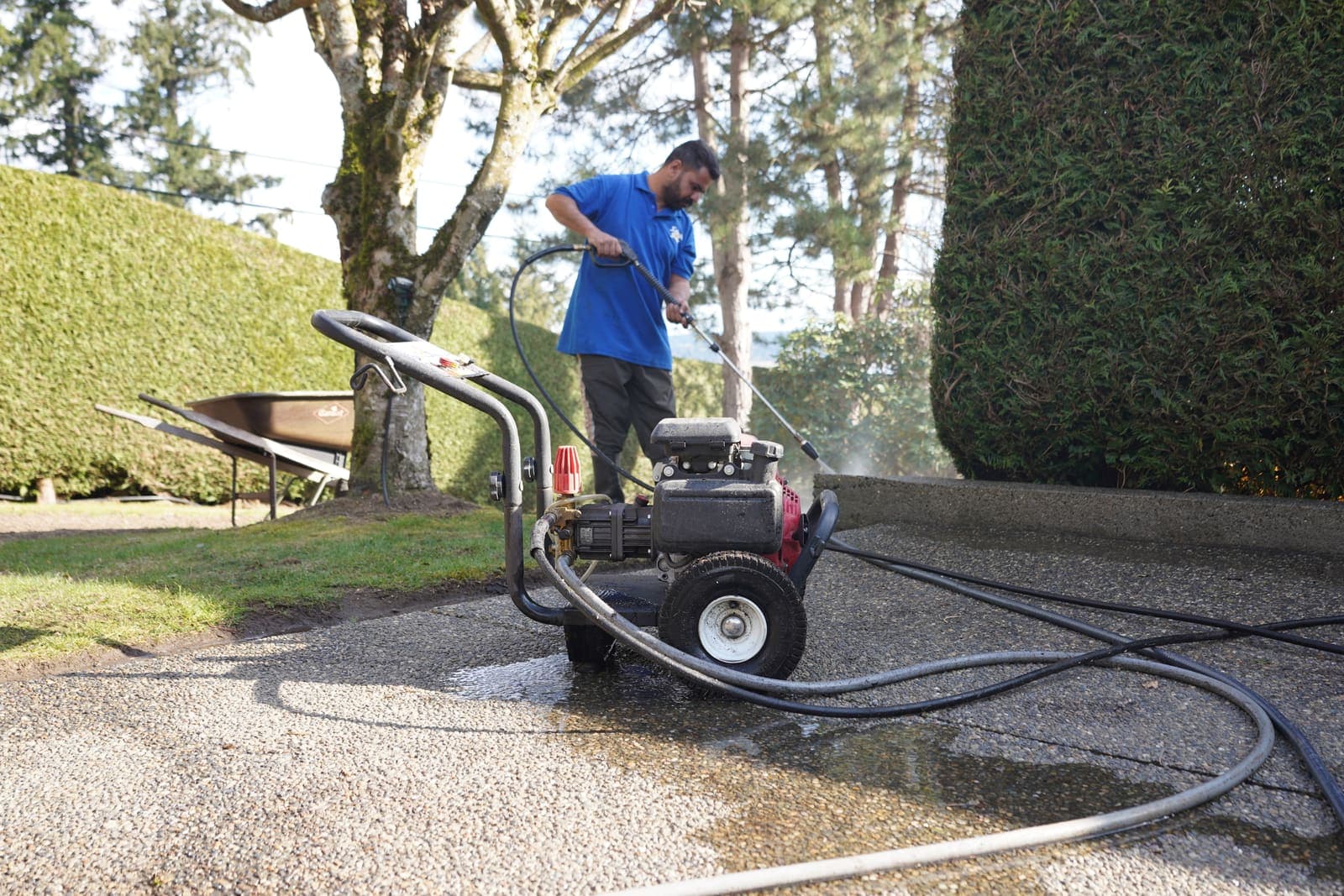 Petrol pressure washer running on a driveway during a cleaning job