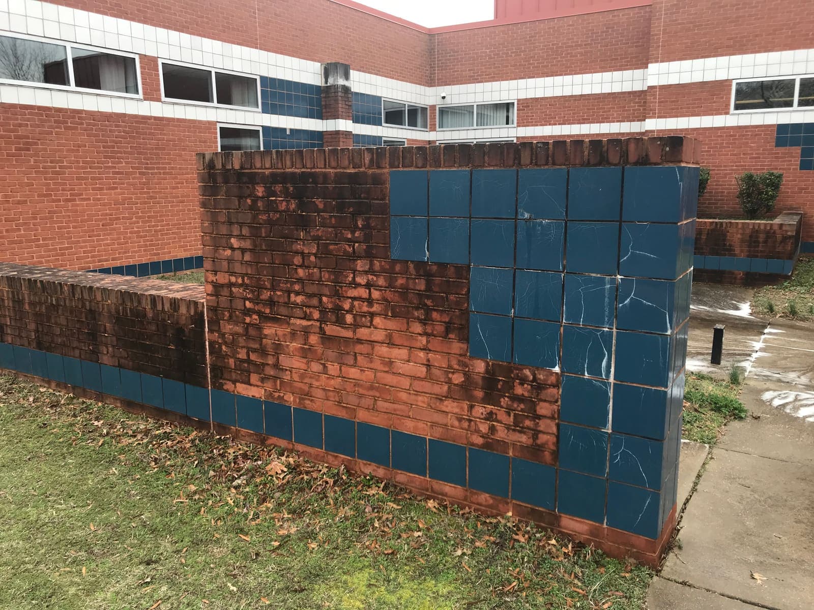 Rust-stained tile and brick wall before restoration cleaning