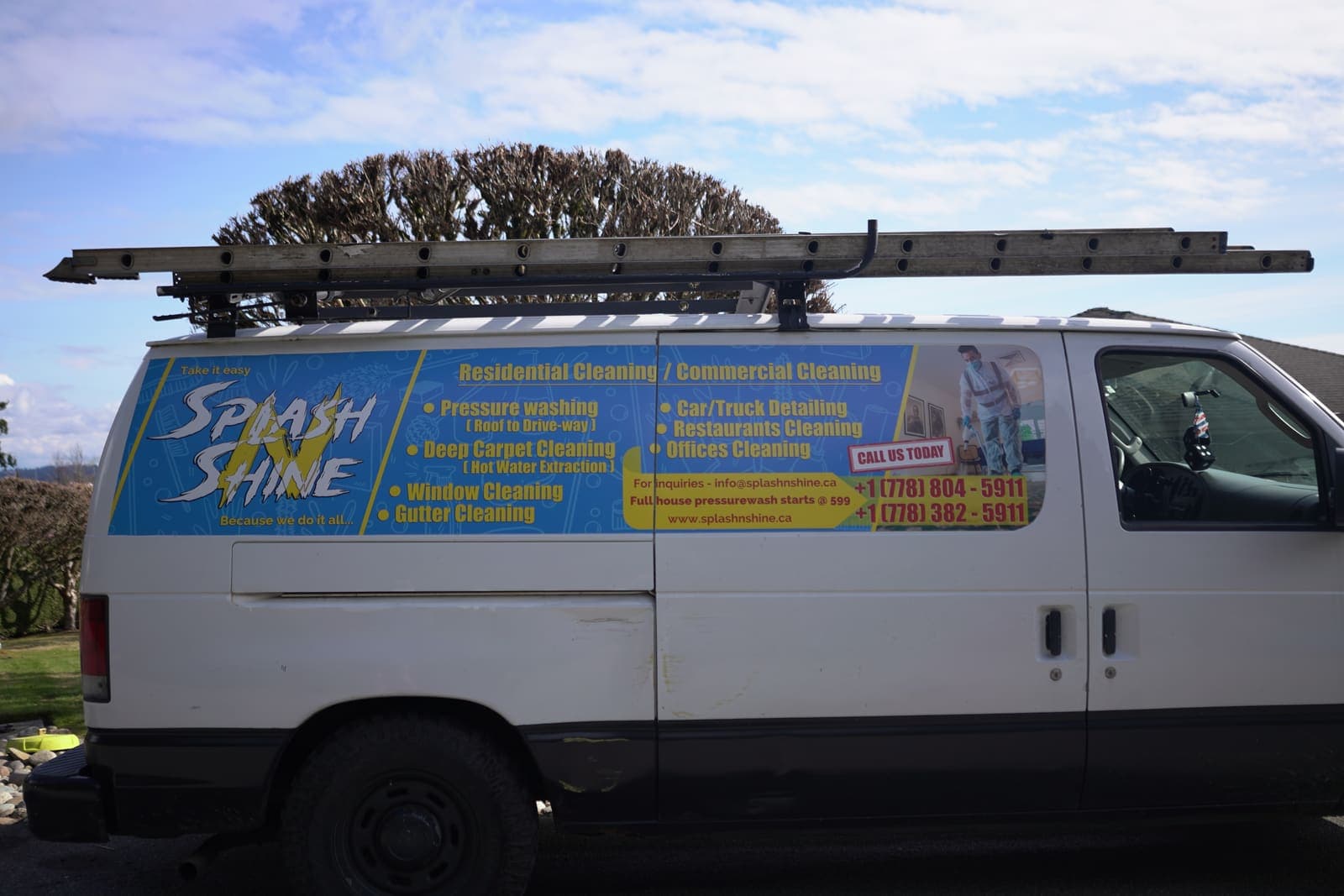 Side view of the service van carrying ladders on the roof rack