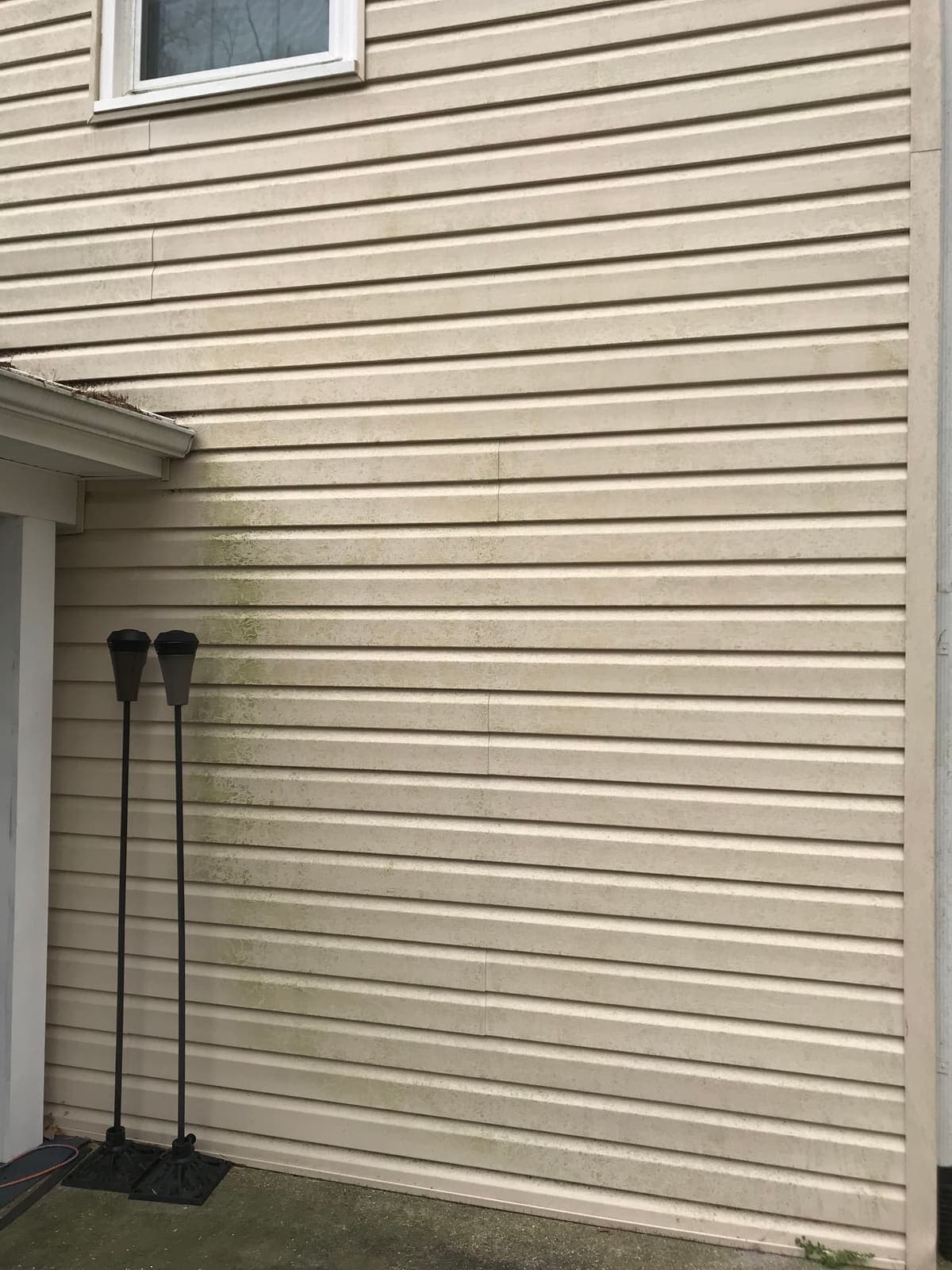 Siding and downspout run before a house washing