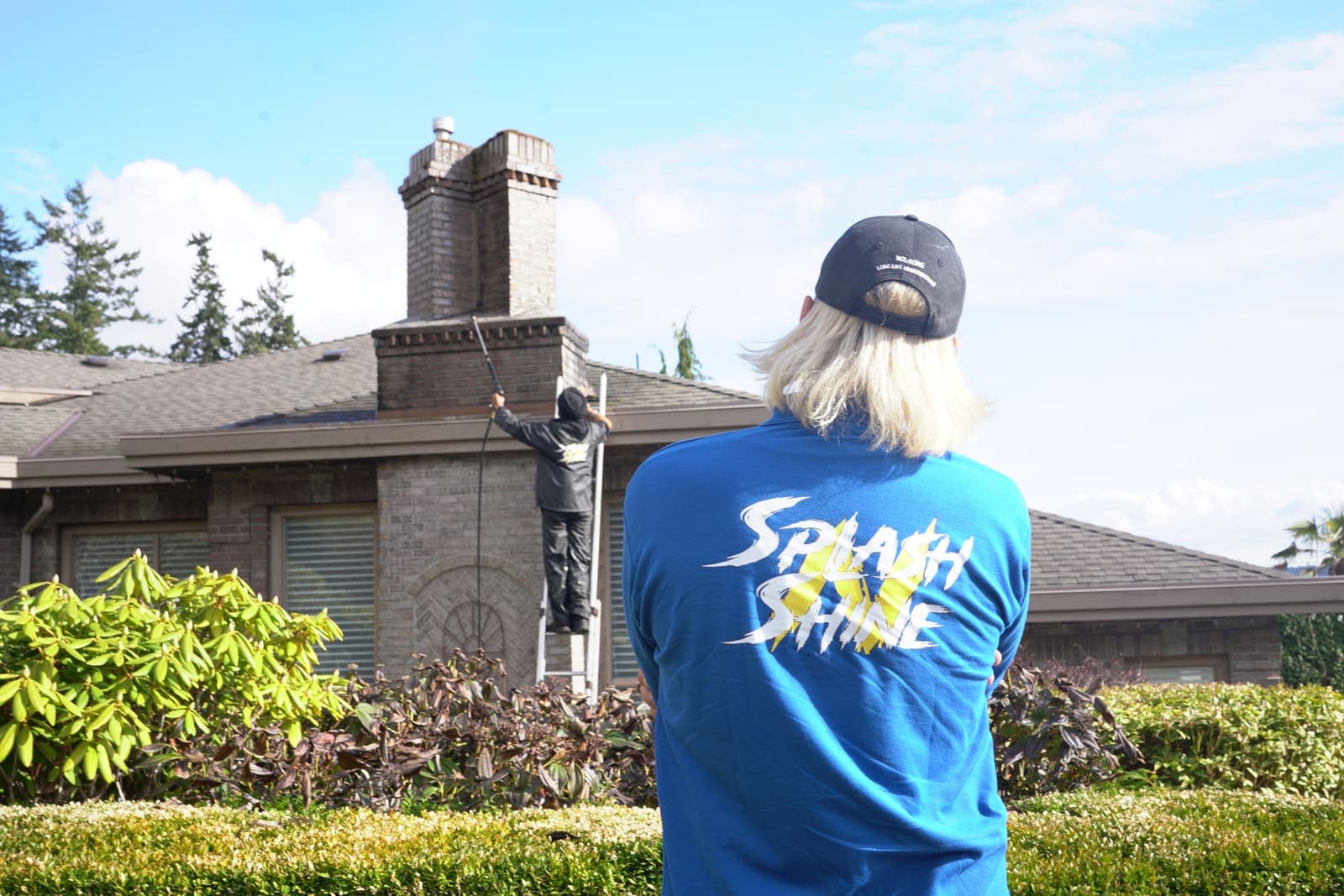 Supervisor watching a technician work on the roof from the ground