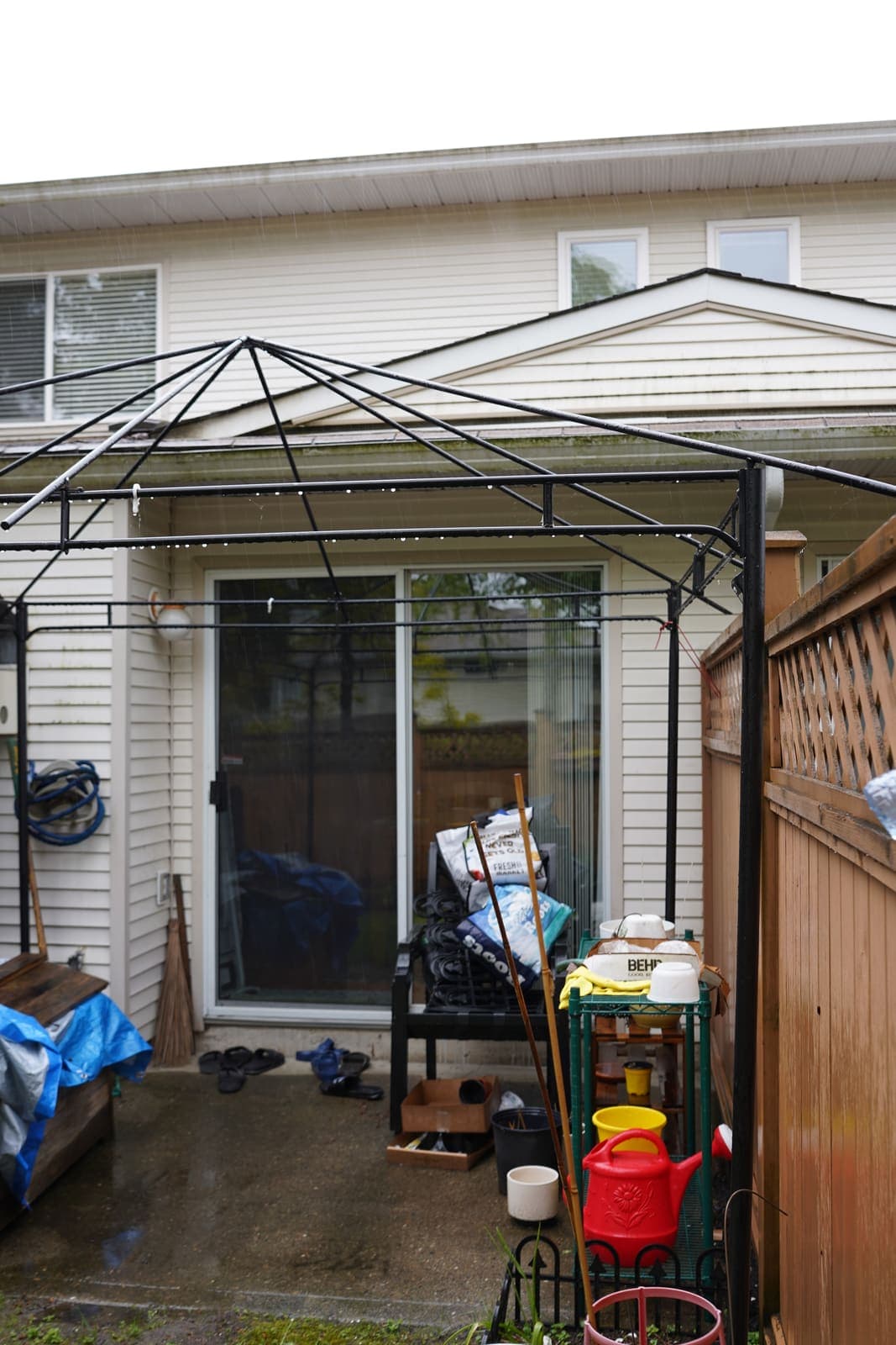 Covered townhouse patio cluttered and dirty before cleaning