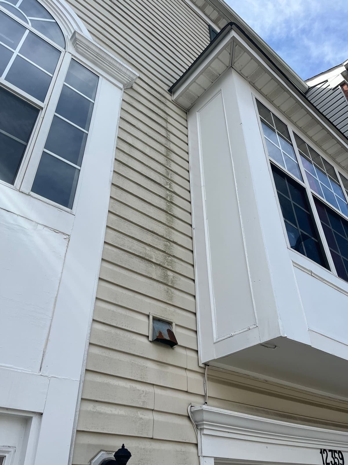 White siding and bay window after cleaning