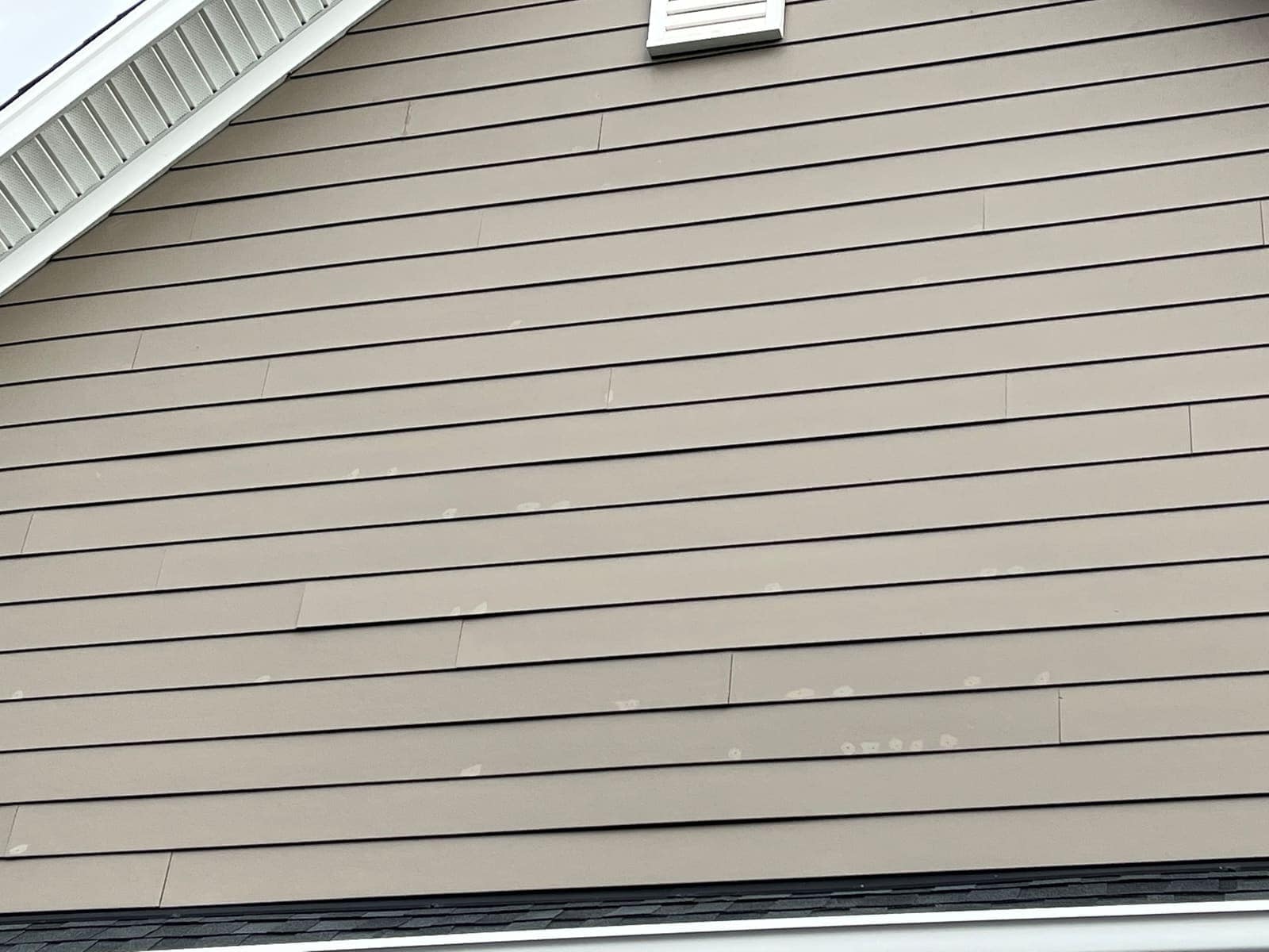 Wide siding panel showing dirt build-up before washing