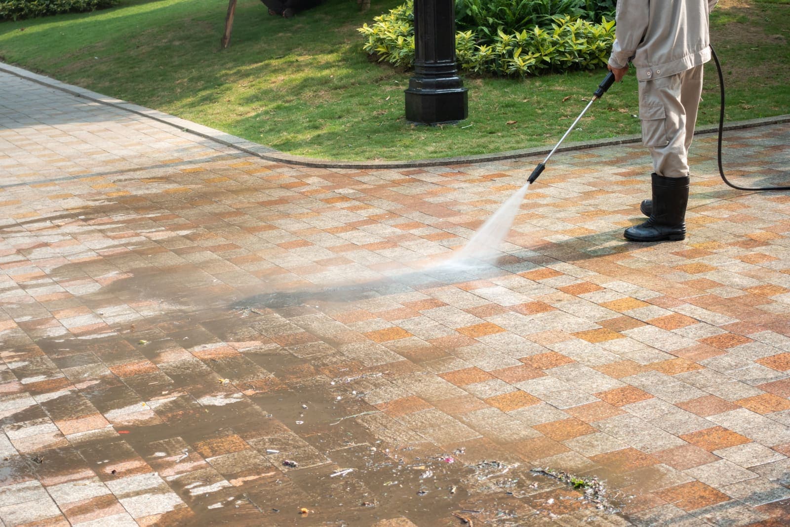 Interlocking paver driveway being pressure washed, dirt lifting from the joints